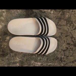Adidas black and white striped slides.